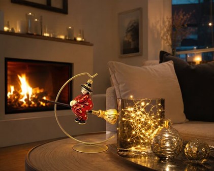 Juledekoration. Håndlavet glas heks i rød kjole og på en kosteskaft