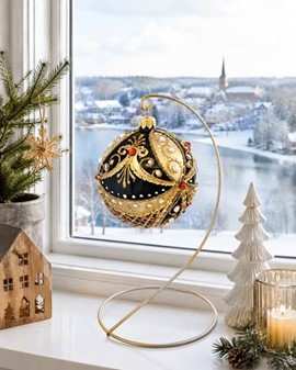 Guld/sort juletræskugle dekoreret med hvide perler og røde krystaller
