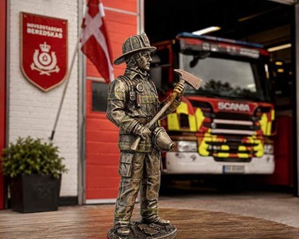 GAVE TIL BRANDMAND. Figur af brandmand i hjelm og med en øks i hånden