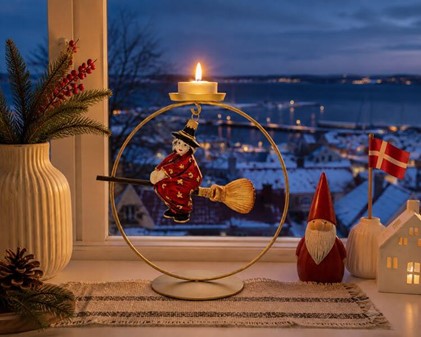 Juledekoration. Håndlavet glas heks i rød kjole og på en kosteskaft